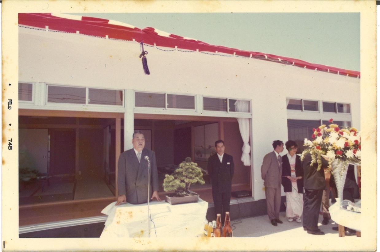 1976年の工場落成式。建物の前で挨拶が行われている。